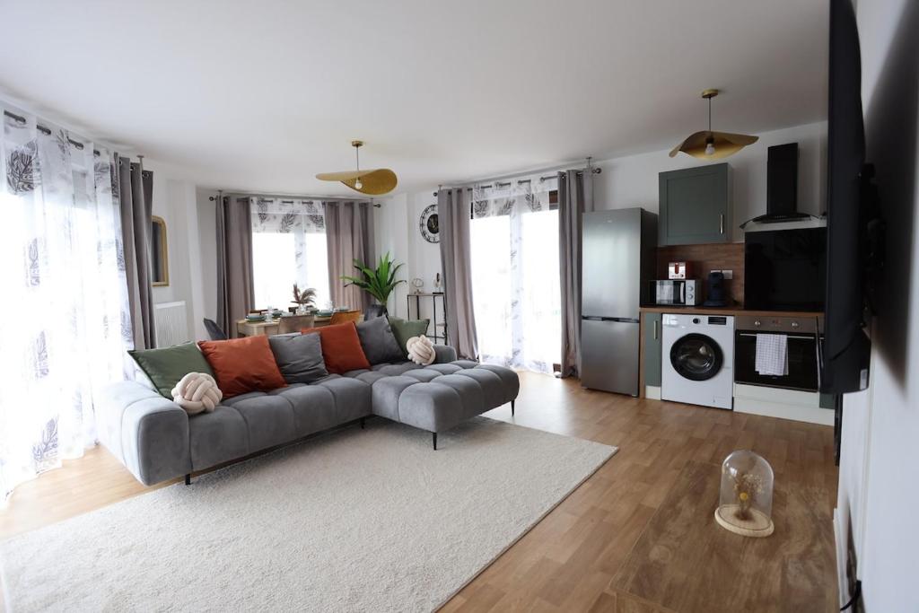 un salon avec un canapé et une cuisine dans l'établissement Apartment 10 min from Disney, à Bussy-Saint-Georges