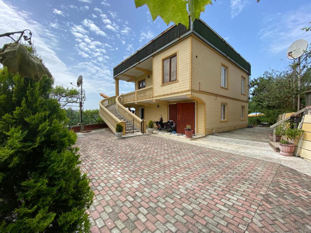 a house with a staircase and a brick driveway at The Bondo's Villa in Kobuleti