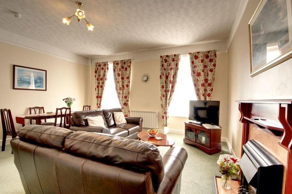 Una sala de estar con un sofá y un televisor. en Tracy, en Barnstaple