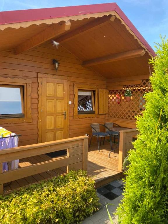 a wooden cabin with a table and a patio at 7 Seas in Wrzosowo