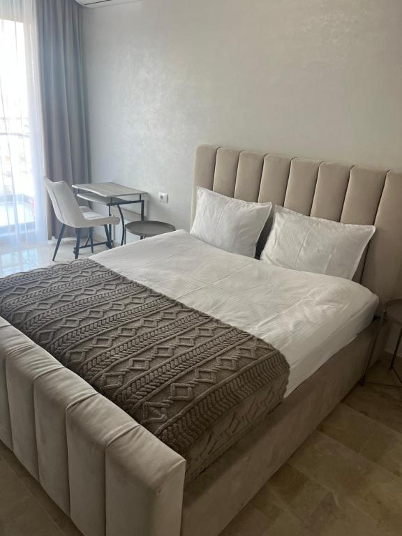een groot bed in een slaapkamer met een tafel en stoelen bij SIGMA suites in Constanţa