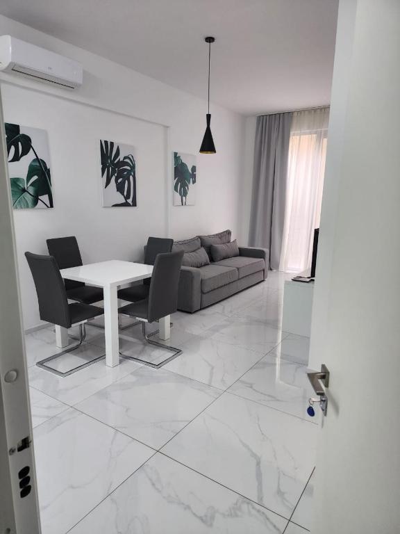 a white living room with a table and a couch at Apartment Del Mare in Boreti