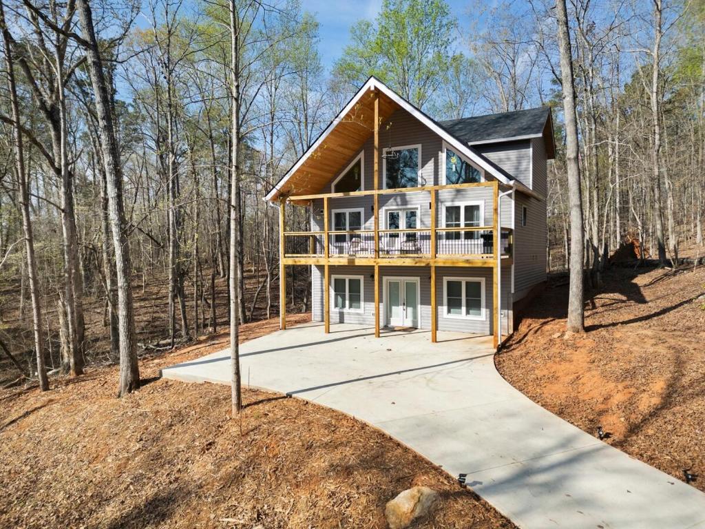 a house in the woods with a porch at Lake Hartwell Escape!- Cabin for groups & families in Westminster