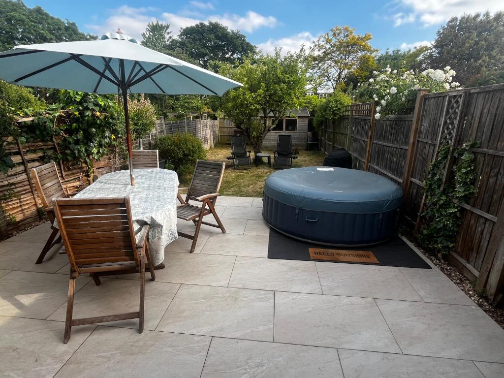 a patio with a table and an umbrella and a hot tub at Wimbledon fortnight in London