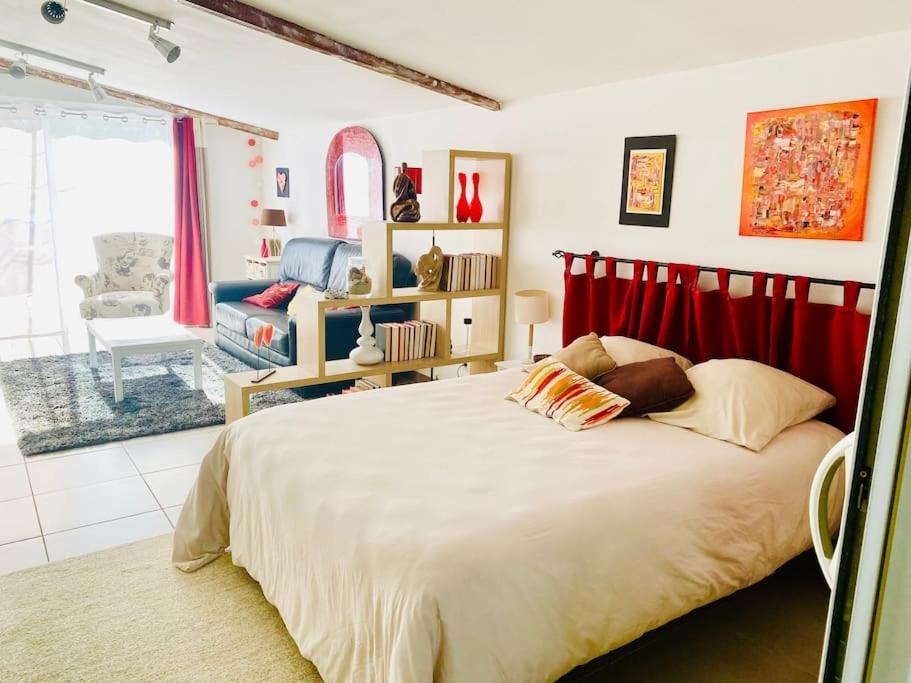 une chambre avec un grand lit et un salon dans l'établissement Villeneuve Ravissante suite à 10mn de Forcalquier, à Villeneuve