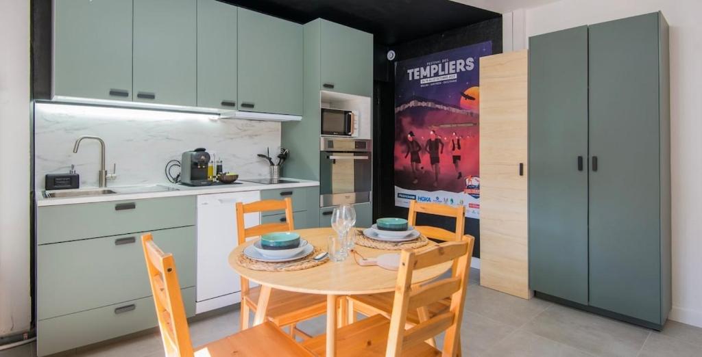 une cuisine avec une table et des chaises dans une cuisine dans l'établissement Le Voyage, à Millau