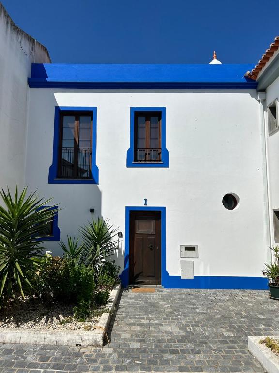 a white house with blue trim and a door at Alqueva - Casa Da Luz in Mourão