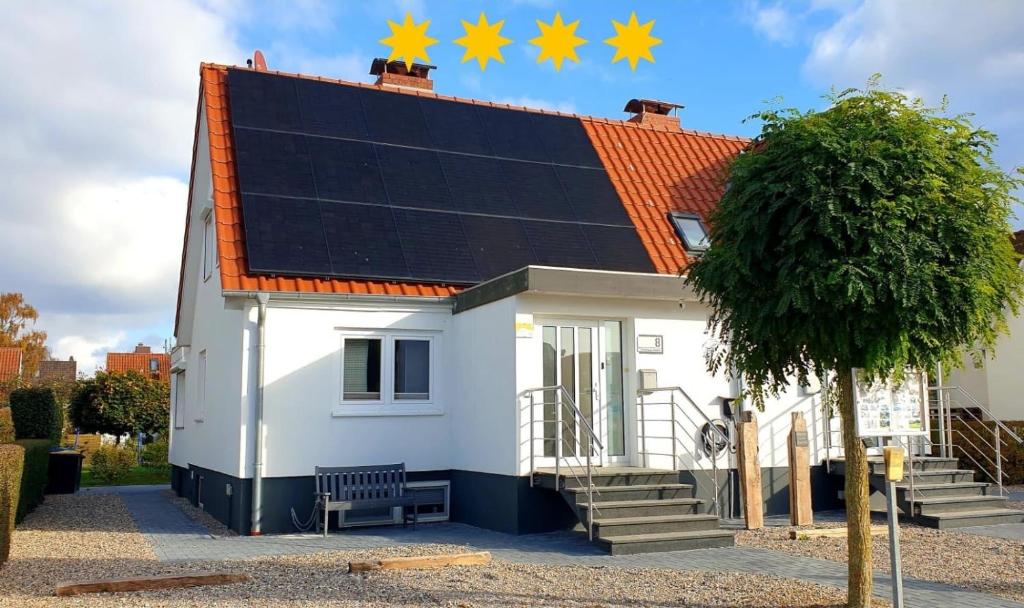 una casa blanca con un panel solar en el techo en Ferienhaus Angela Kellenhusen - 6 Personen 3 Schlafzimmer 4, en Kellenhusen