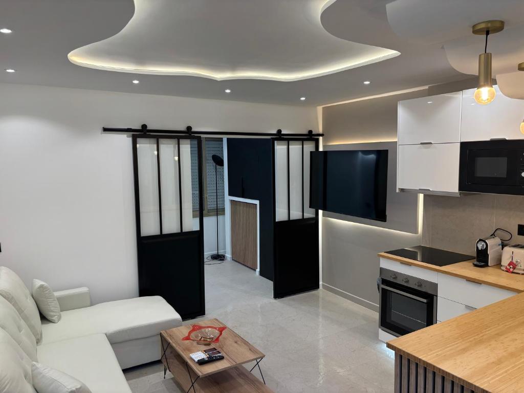 un salon avec un canapé blanc et une cuisine dans l'établissement 2 pièces centre Juan moderne avec piscine tennis, à Antibes
