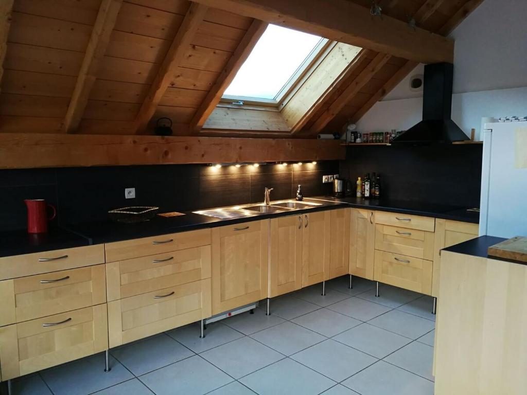 une cuisine avec des armoires en bois, un évier et une fenêtre dans l'établissement cottage with view of La Grave La Meije, à La Grave