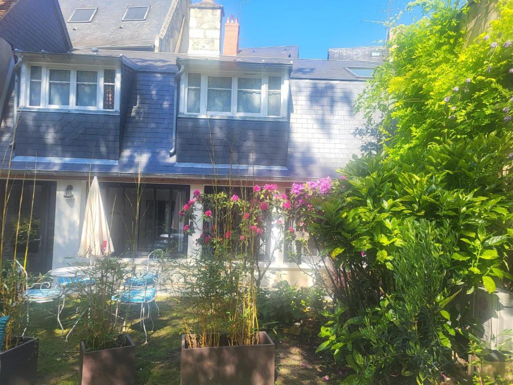 une maison dotée d'une cour avec des plantes devant elle dans l'établissement Au puits de l'abbaye, à Bourges