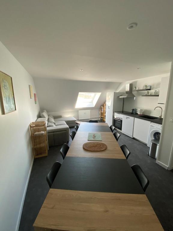 une longue table dans une pièce avec un canapé et une cuisine dans l'établissement Appartement à la montagne 10 chambres 5 douches and 4 WC, à Argelès-Gazost
