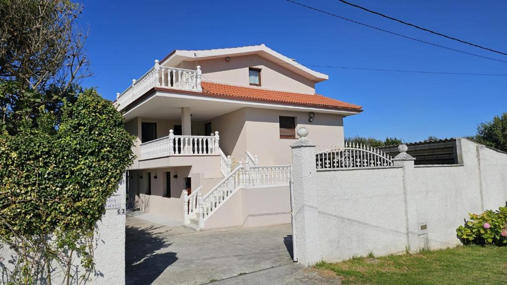 una casa blanca con una valla blanca en Area Pequena ATICO, en Malpica de Bergantiños