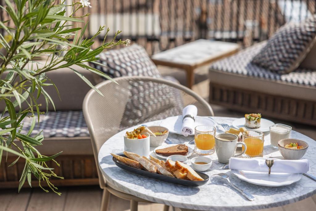 a table with a tray of breakfast food on it at Hôtel Singulier Bordeaux - Boutique Hôtel & Spa Anne Semonin in Bordeaux
