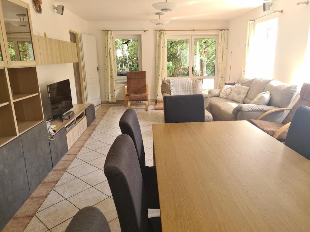 a living room with a table and a couch at Rodinný dům v Praze s bazénem in Prague
