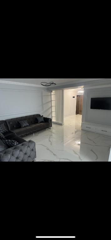 a living room with a television and a white floor at Adu Luxuri apartament in Rădăuţi