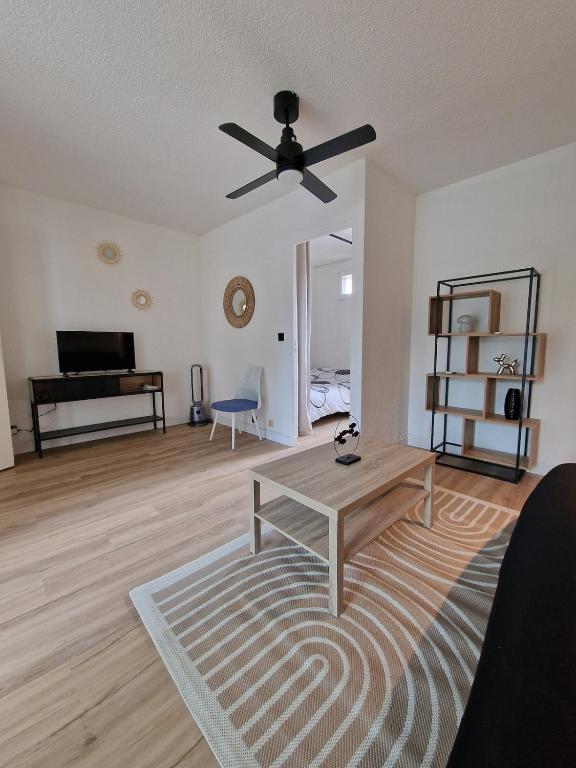 - un salon avec un ventilateur de plafond et une table dans l'établissement Studio centre 100 m plage et port avec parking, à Saint Cyprien Plage