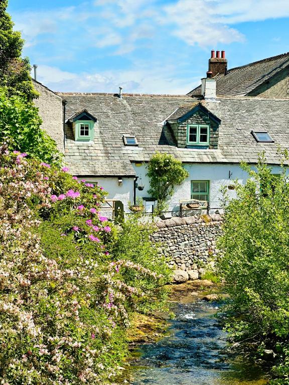 a group of houses with a stream in front at Cottage On The Brook in Braithwaite