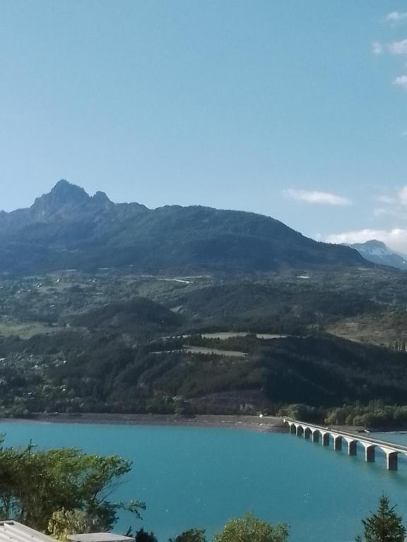 une vue d'un lac avec des montagnes en arrière-plan dans l'établissement Lac et étoiles, à Savines