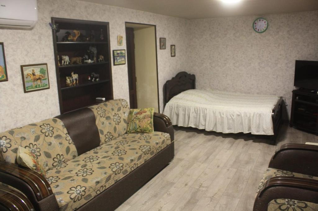 una sala de estar con un sofá y una cama en Guesthouse - Happy house in Kutaisi, en Kutaisi