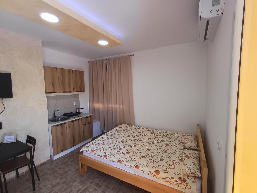 a small bedroom with a bed and a kitchen at Airport view Apartment in Belgrade