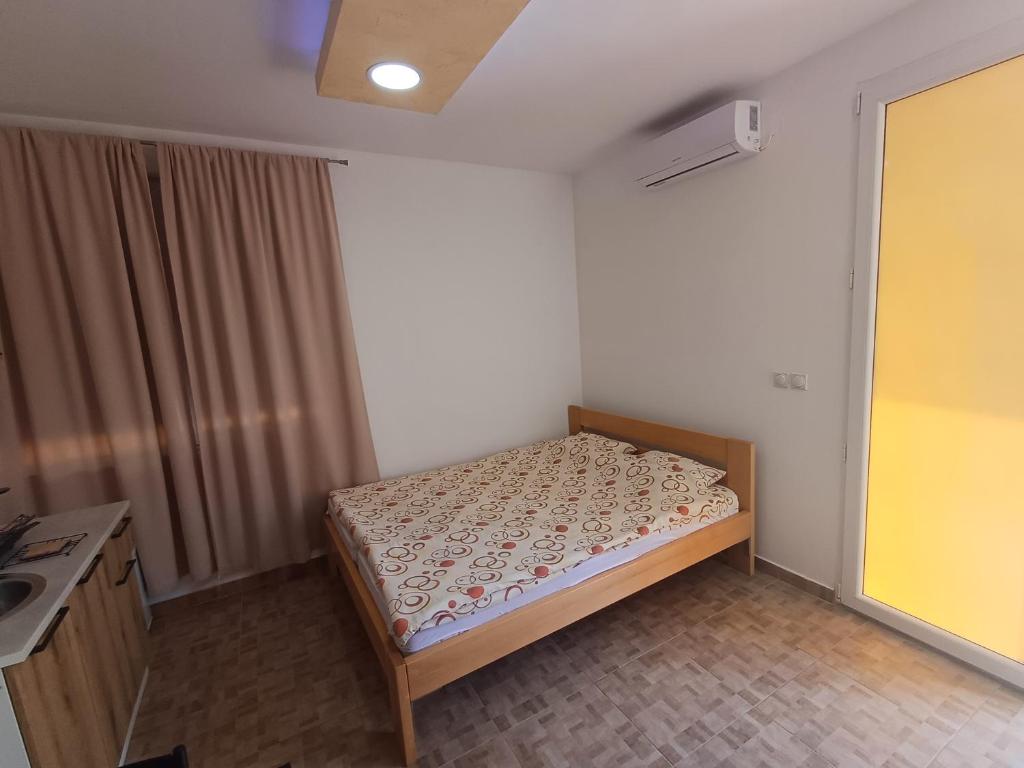 a small bedroom with a bed and a sink at Airport view Apartment in Belgrade