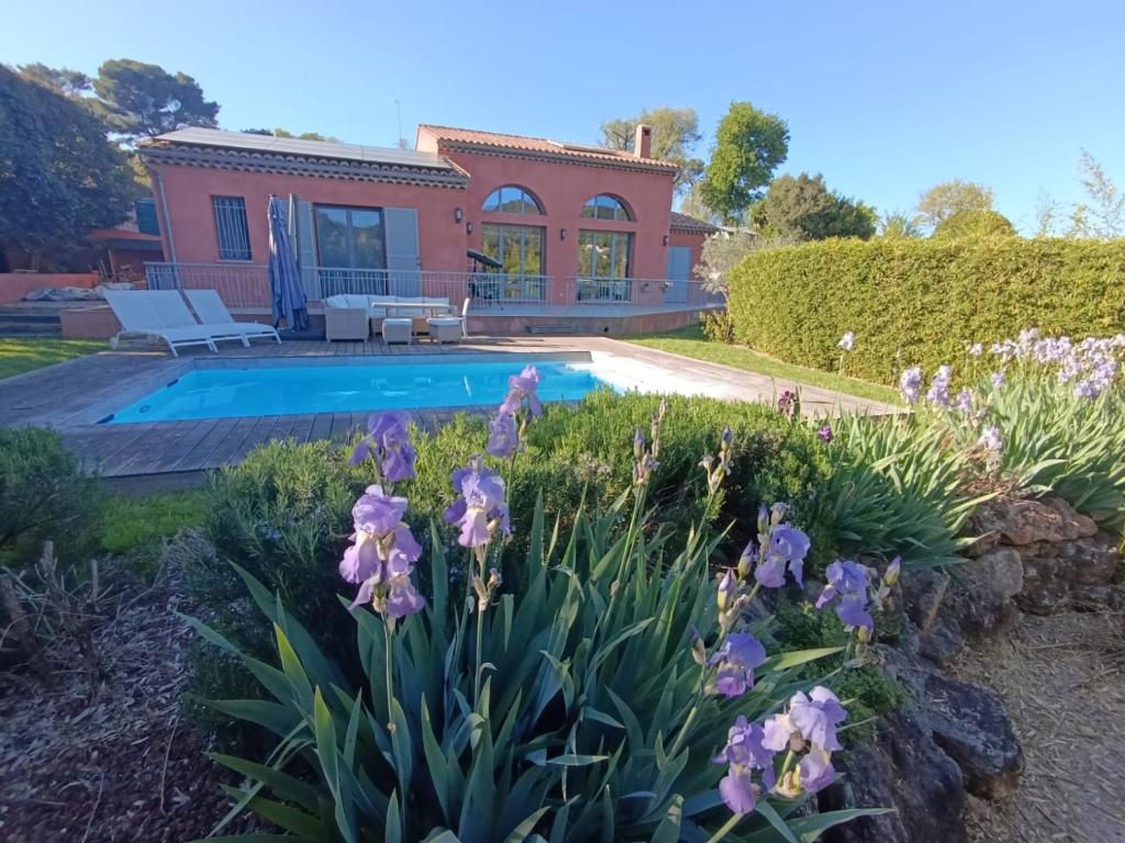 une maison avec une piscine et des fleurs violettes dans l'établissement Villa près de la mer, à Vallauris