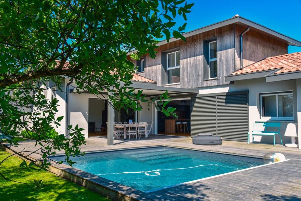 une maison avec une piscine devant une maison dans l'établissement Villa Landa, à Angresse