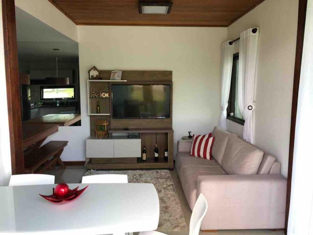 ein Wohnzimmer mit Sofa und Fernseher in der Unterkunft Bangalô monte castelo in Sairé