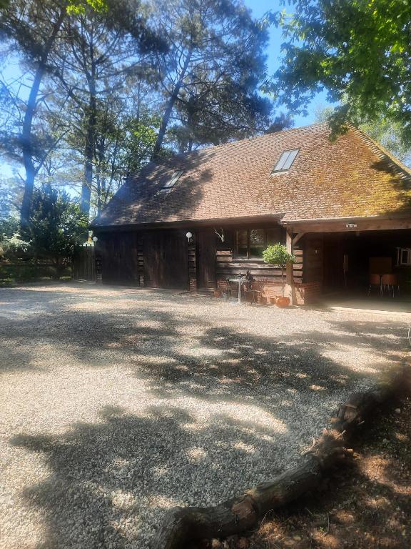a house with a roof with a table and chairs at The Barn at Creech View in Wareham