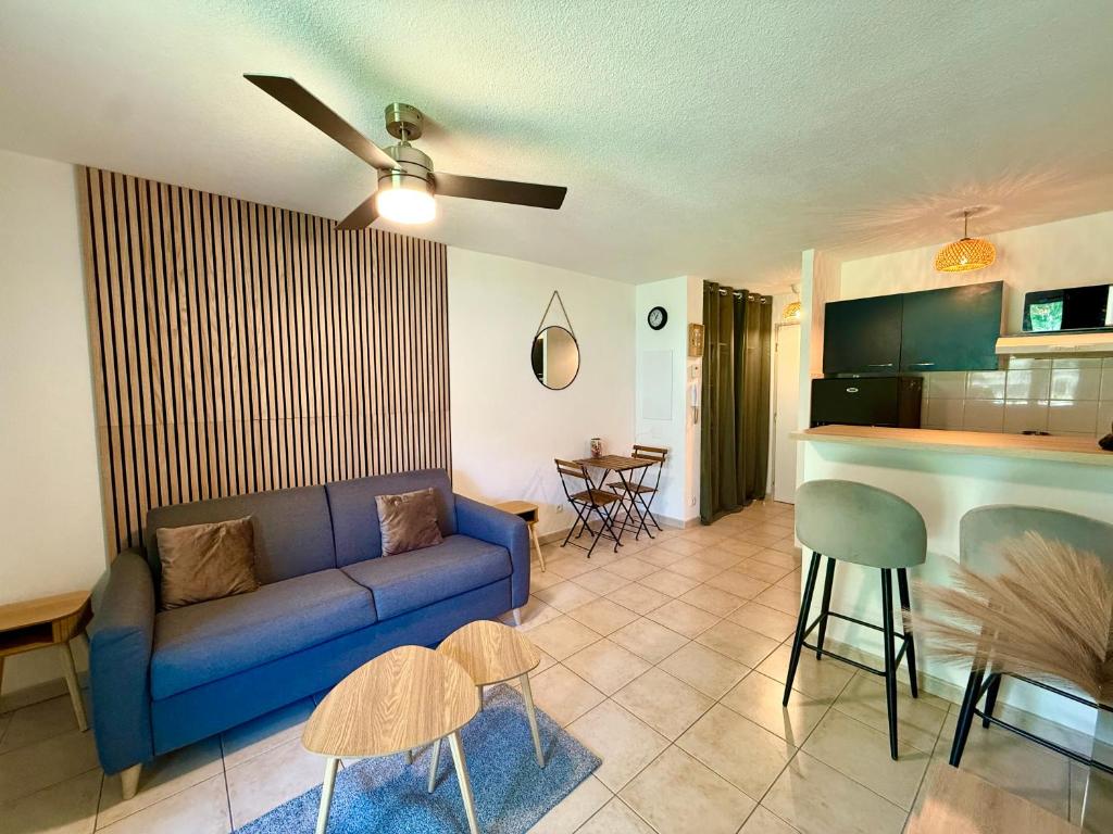 un salon avec un canapé bleu et une cuisine dans l'établissement Lum'Arles, à Arles