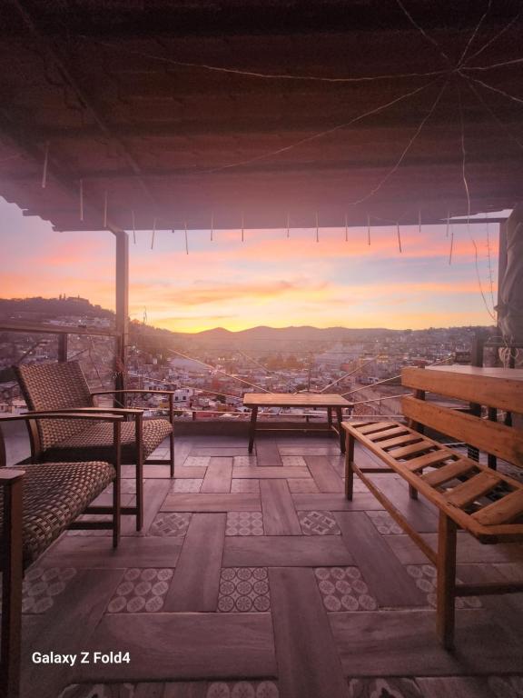 eine Terrasse mit Bänken und Stadtblick in der Unterkunft Casa Linda Vista 2 in Cedro