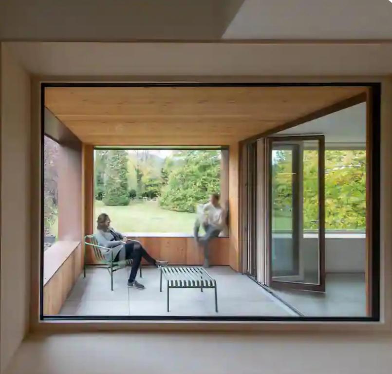 deux personnes sont assises sur un balcon dans une maison dans l'établissement Appartement design dans un écrin végétal, à Scherwiller