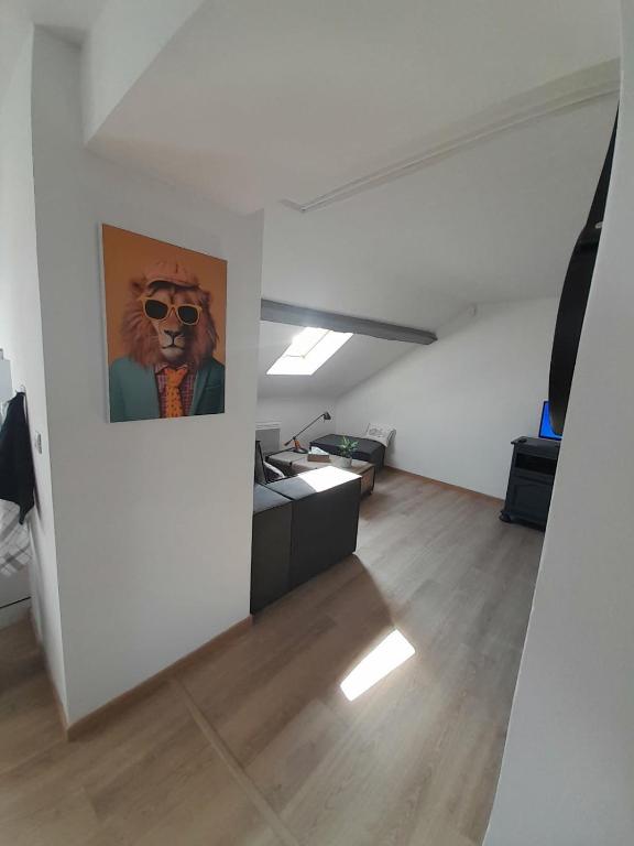 un salon avec un tableau représentant un lion avec des lunettes de soleil dans l'établissement Apaartement près du Stade du Hainaut, à Marly