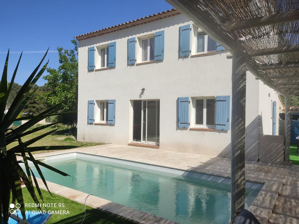 une piscine devant une maison dans l'établissement Villa T5 Les Volets Bleus, piscine, à l'entrée de Cassis et de ses calanques, à Roquefort-la-Bédoule