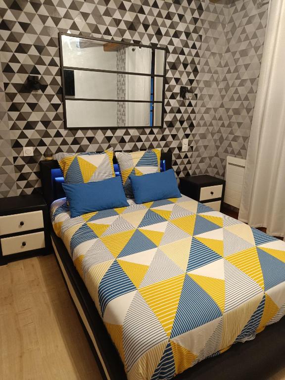 une chambre avec un lit avec une couette colorée dans l'établissement Corneguerre Grand Brassac, à La Peyzie