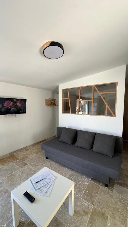 un salon avec un canapé et une table dans l'établissement Lappartement du sud, à Saint-Quentin-la-Poterie