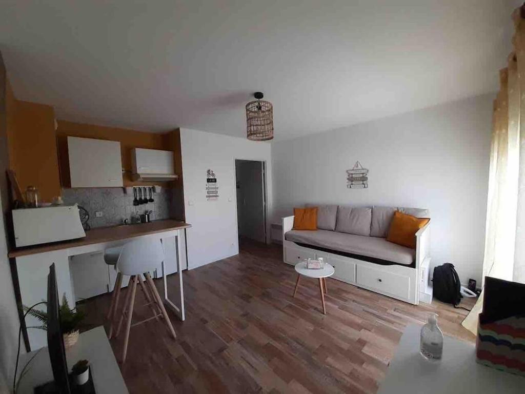 un salon avec un canapé et une table dans l'établissement Laïa, studio type Scandinave, wifi, parking, à La Rochelle