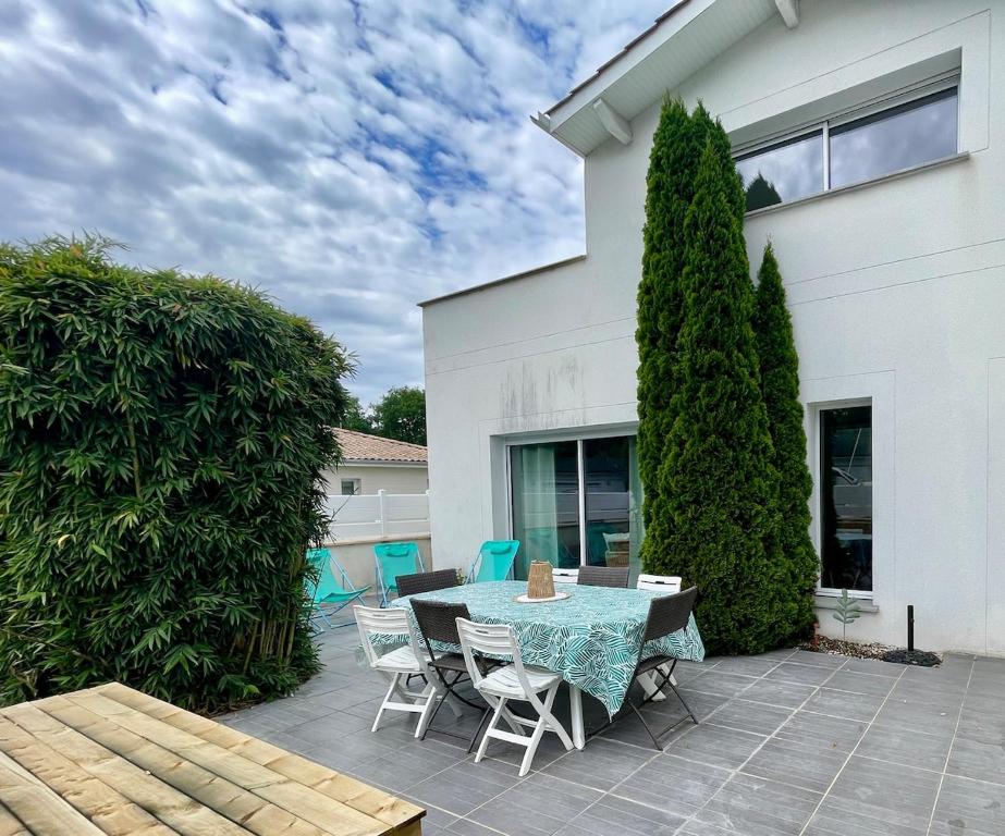 un patio avec une table et des chaises et un bâtiment dans l'établissement Bordeaux, ocean and vineyards, à Le Pian-Médoc