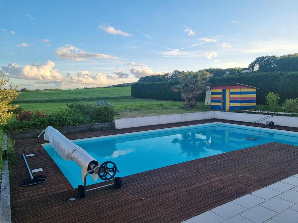 a pool with a water cannon on a wooden deck at Villa paisible avec piscine proche Toulouse in Eaunes
