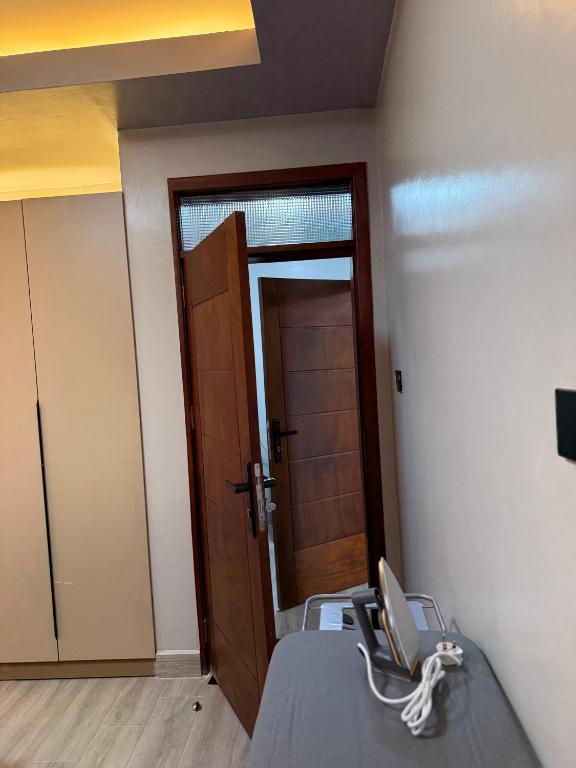 a room with a bed and a wooden door at Mirembe housing in Nalakonge