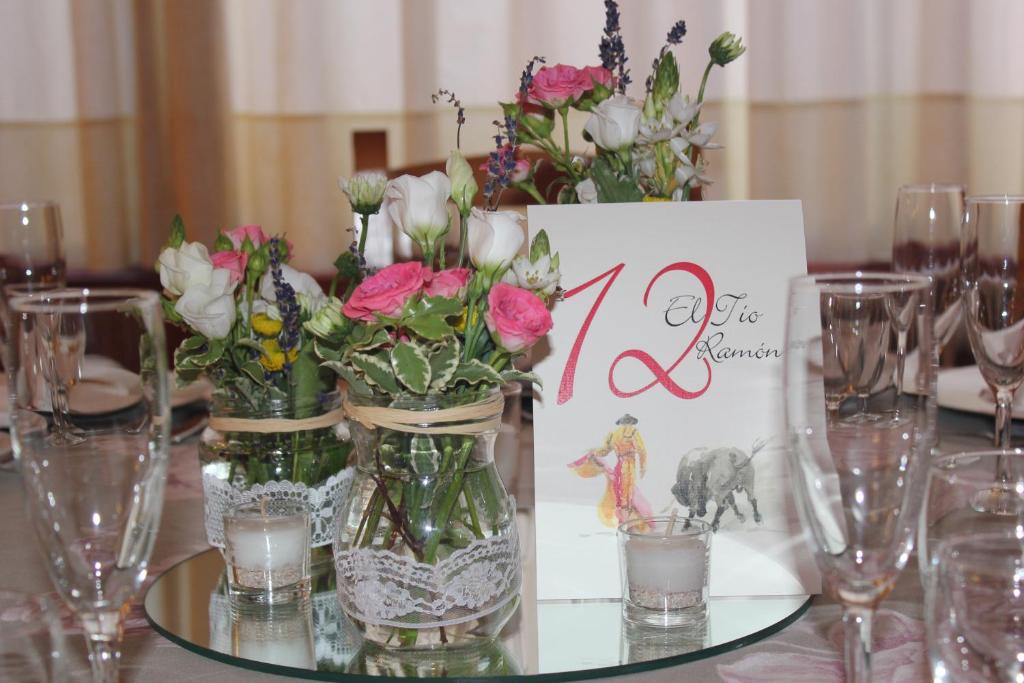 un tavolo ricoperto di vasi pieni di fiori e un cartello di Atalaya a Bogarra