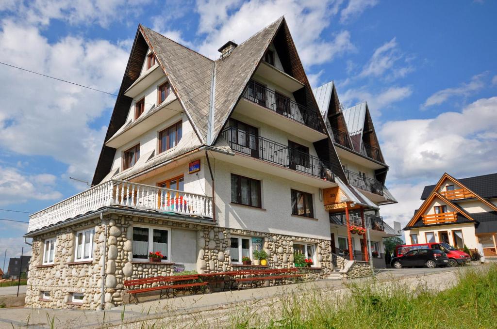 a large house with a gambrel roof at Pokoje Gościnne Janina in Zakopane