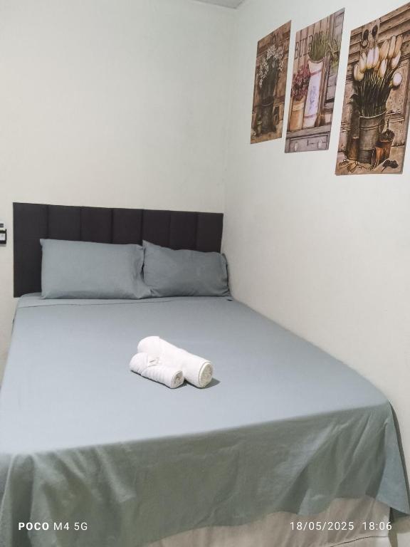 a bed with a towel laying on it at Pousada Santos lll, kitnet confortável com ar condicionado in Londrina