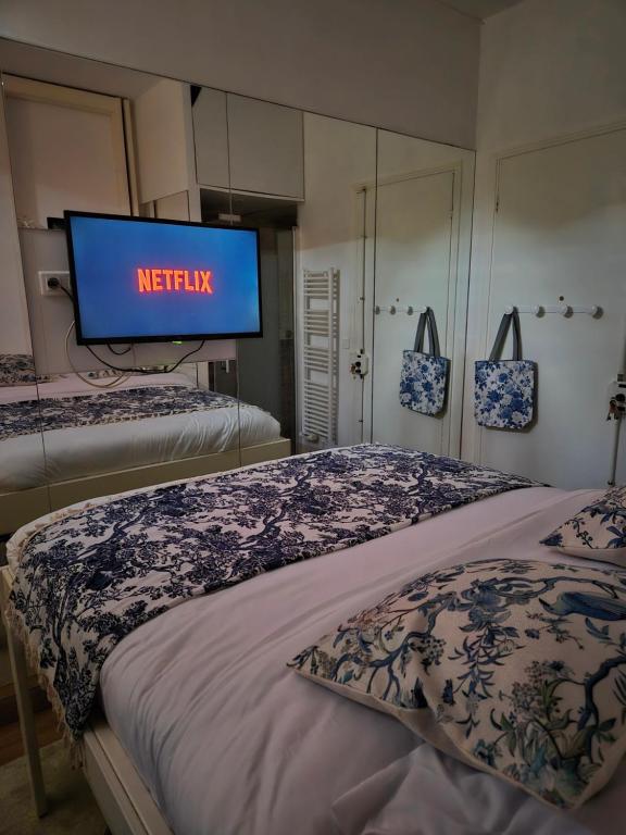 une télévision dans une chambre avec deux lits et un lit carré dans l'établissement Studio 10m2 Cosy sur Nice, à Nice