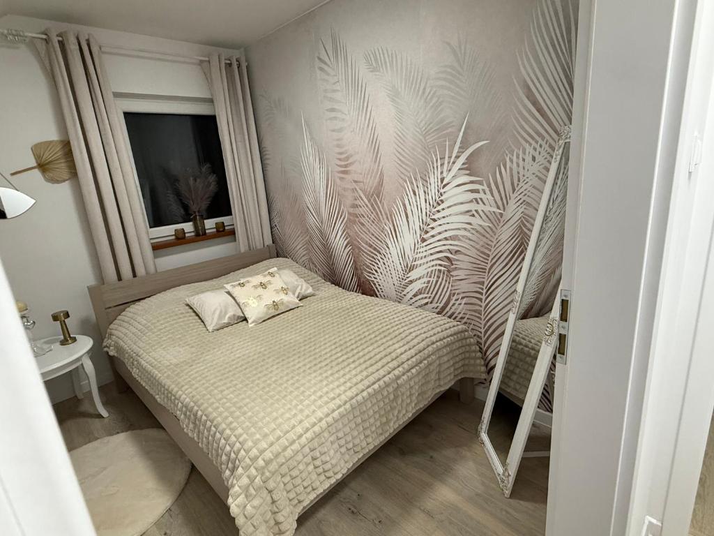 um pequeno quarto com uma cama e uma janela em Bezdroża Mazurskie em Mrągowo