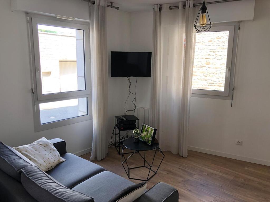 un salon avec un canapé et deux fenêtres dans l'établissement Next to historic center and port of Vannes, à Vannes