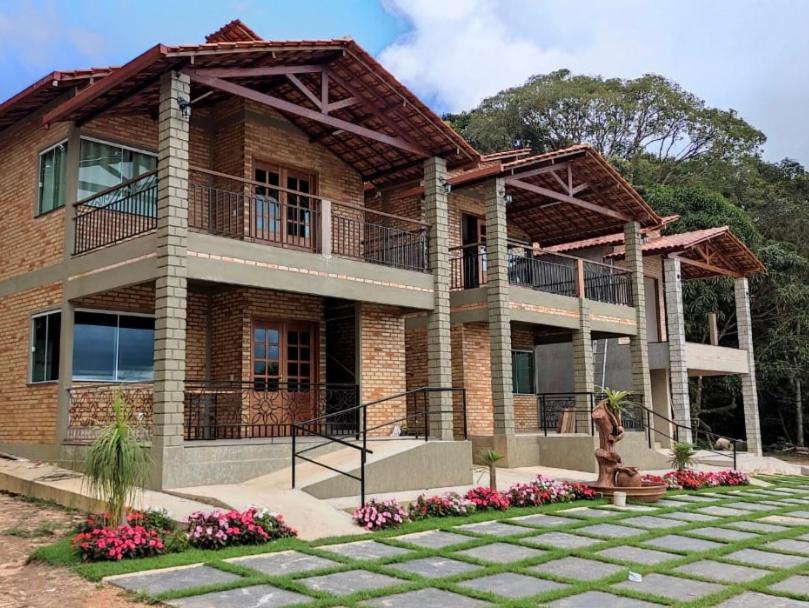 a large brick building with a balcony and a statue at Pousada Flor do Café in Ubajara