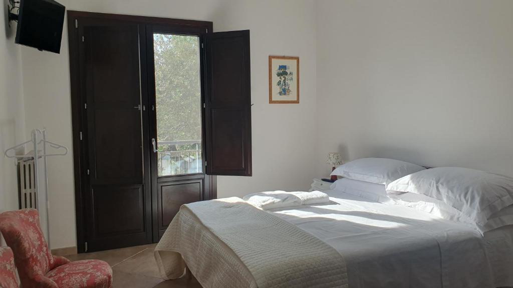 ein Schlafzimmer mit einem Bett und einem Stuhl und einem Fenster in der Unterkunft La Bouganville in Mola di Bari