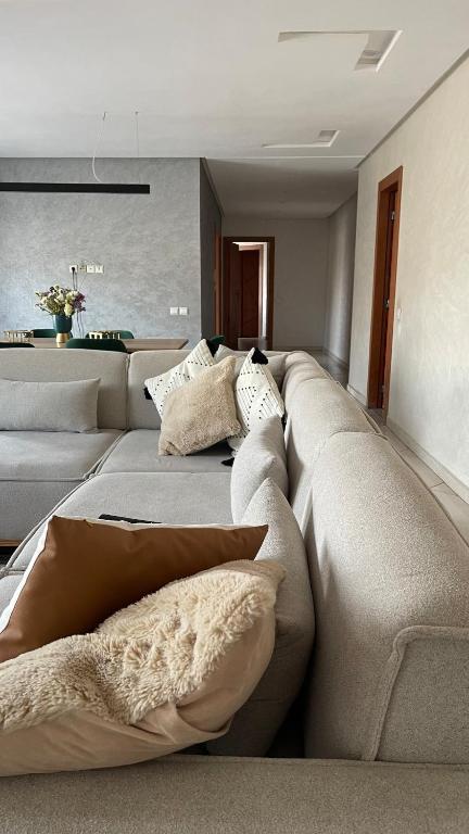a large couch in a living room with pillows on it at Appartement centre ville kenitra in Kenitra